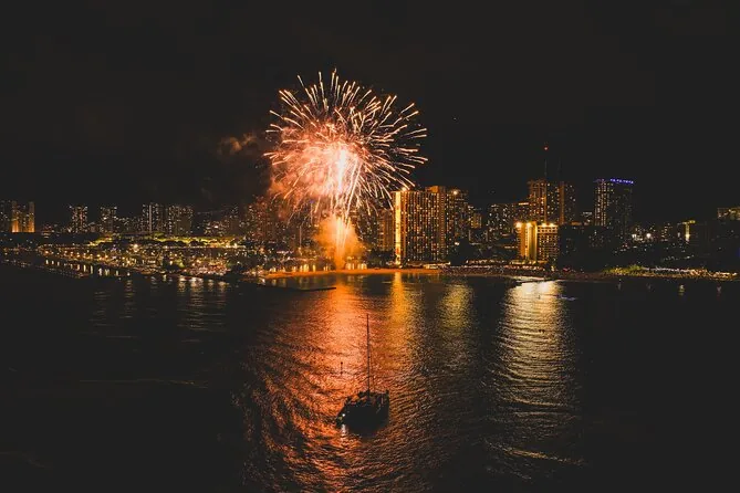 Ein Feuerwerkskörper explodiert über einem Hafen, die Lichter der Stadt spiegeln sich im Wasser